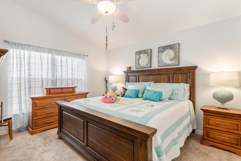 24167 Buckingham Way Punta Gorda, FL 33980 - Photo 17 of 42 a bedroom with a bed and a chandelier