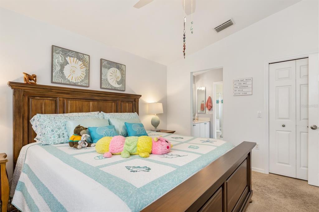 24167 Buckingham Way Punta Gorda, FL 33980 - Photo 18 of 42 a bedroom with a bed and a table in it