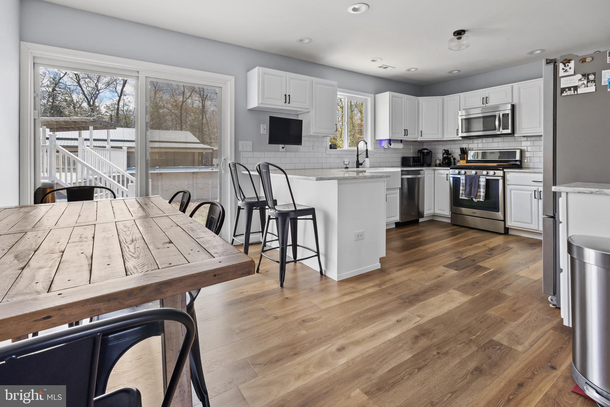 153 Crystal Road Elmer, NJ 08318 - Photo 4 of 29 a large kitchen with kitchen island a large counter top space a sink stainless steel appliances and cabinets