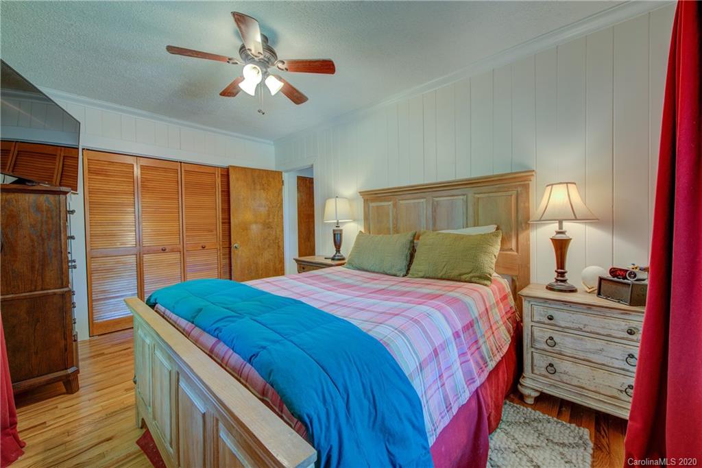 173 Callahan Street Rutherfordton, NC 28139 - Photo 21 of 25 a bedroom with a bed and a chandelier
