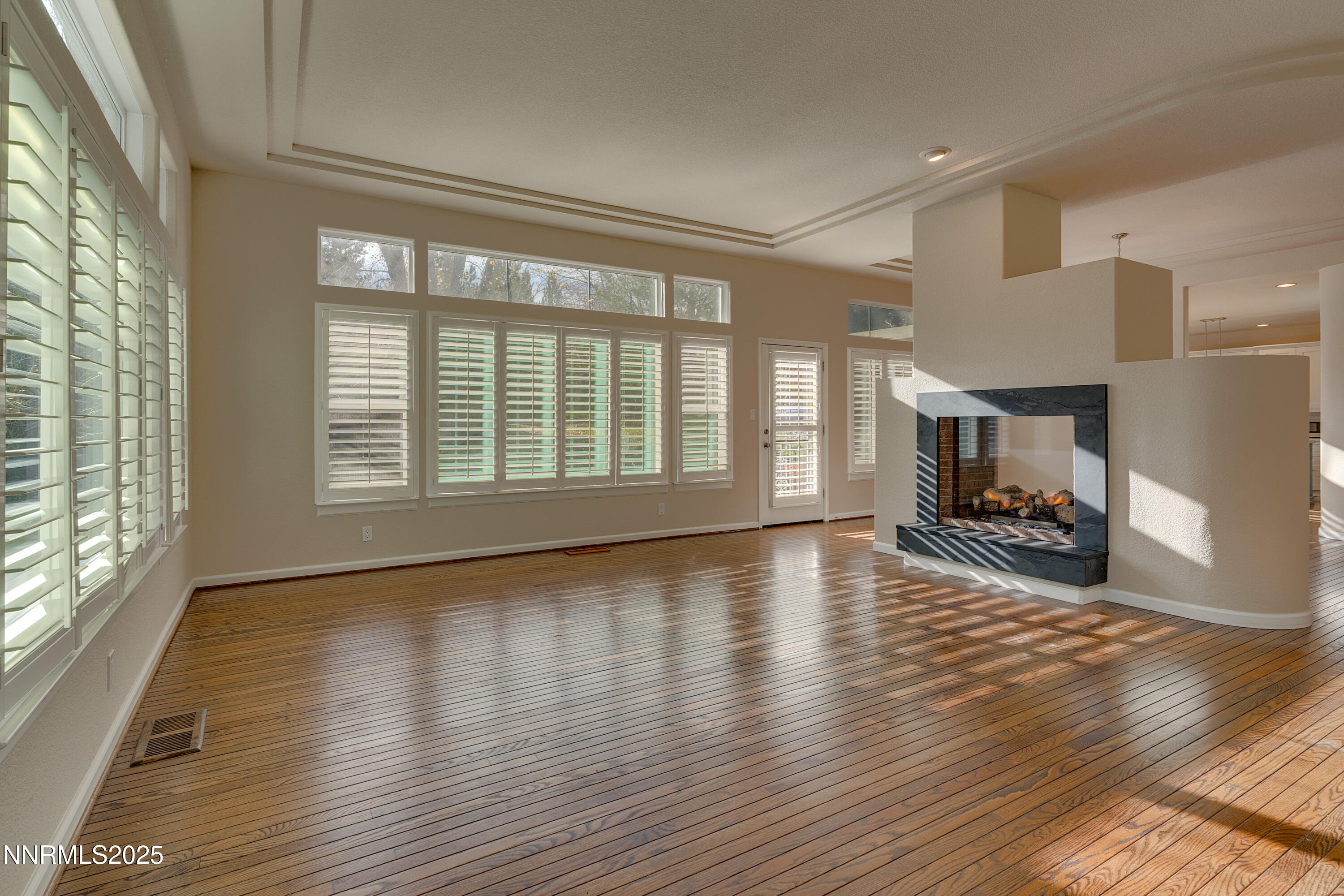 4052 Caughlin Creek Road Reno, NV 89519 - Photo 18 of 37 a view of an empty room with a window and wooden floor
