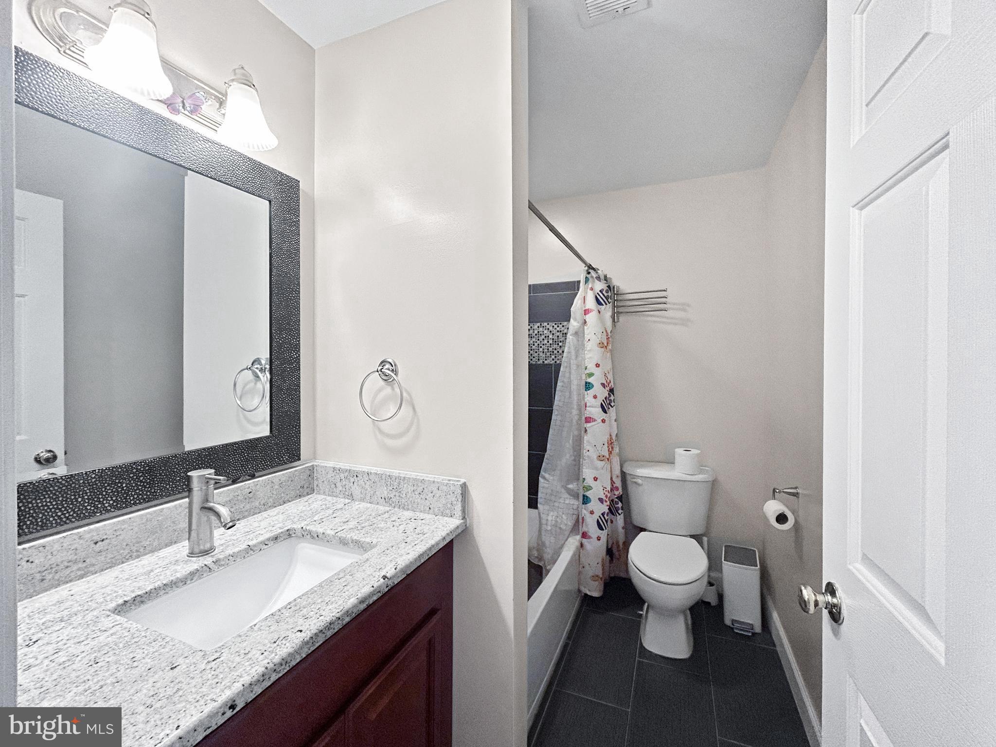 913 Highland Ridge Avenue Gaithersburg, MD 20878 - Photo 23 of 38 a bathroom with a granite countertop sink mirror vanity and toilet