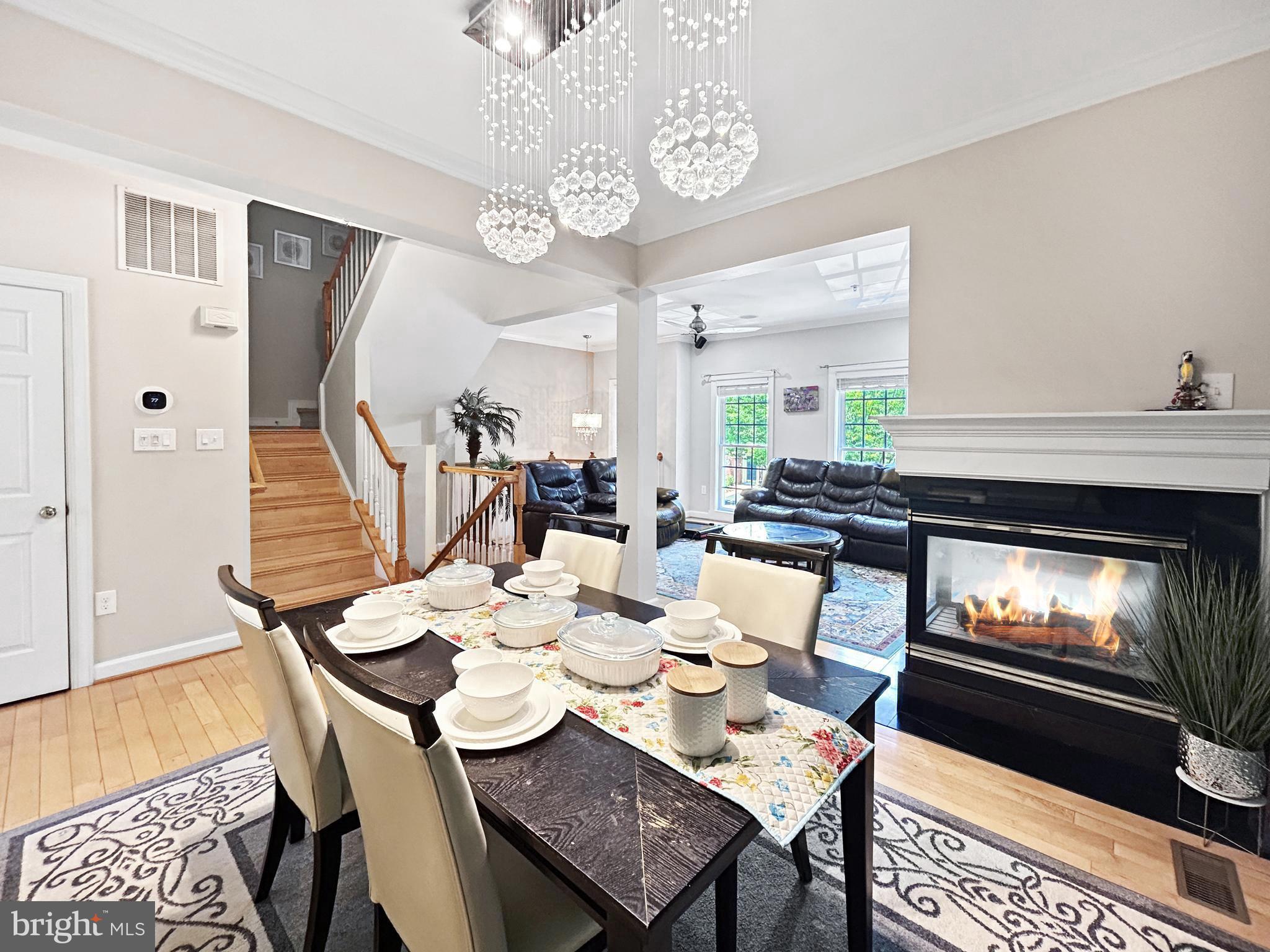 913 Highland Ridge Avenue Gaithersburg, MD 20878 - Photo 7 of 38 a dining room with wooden floor a chandelier a wooden table and chairs