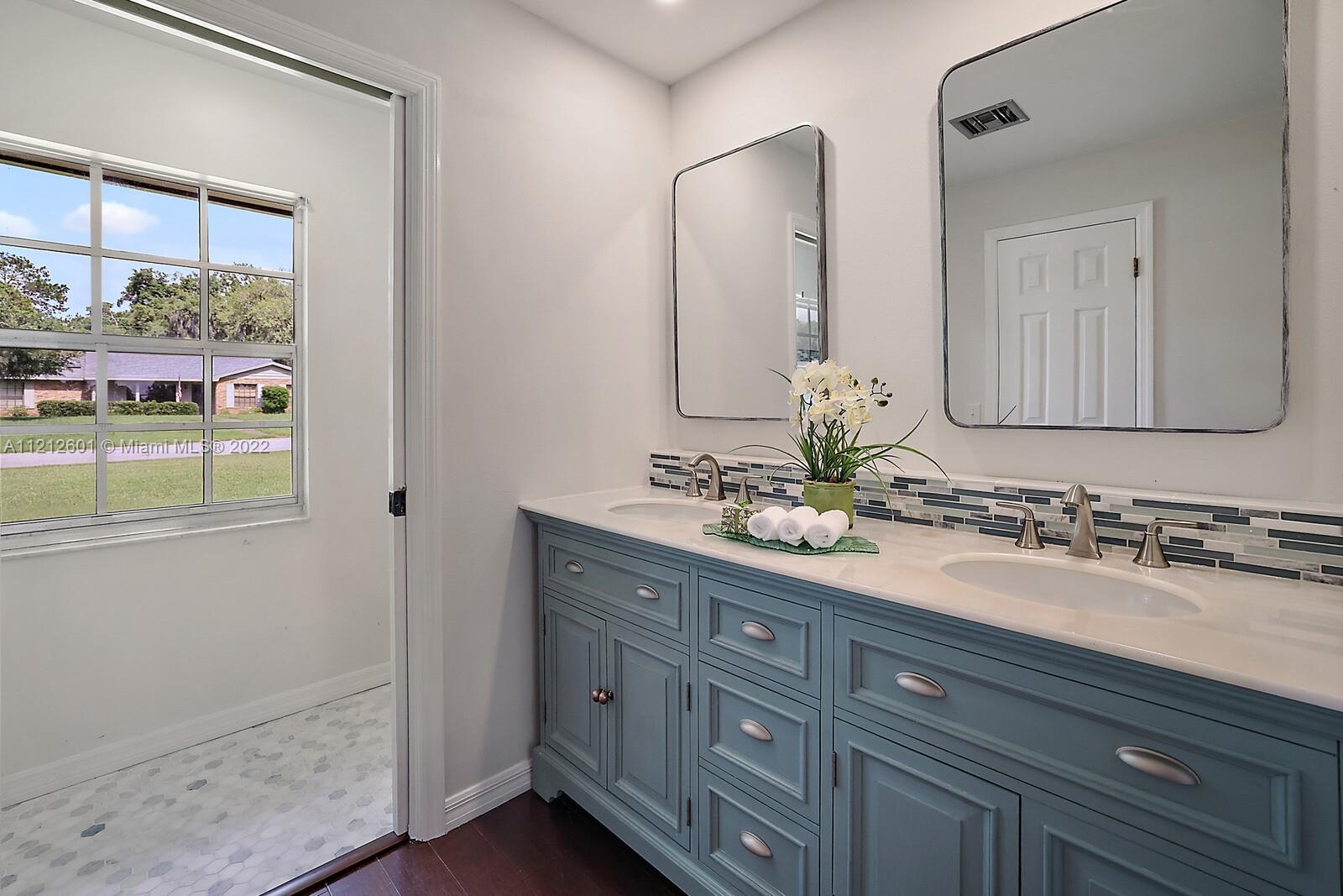 3052 Pine Cove Place Eustis, FL 32726 - Photo 16 of 32 a bathroom with a double vanity sink and a mirror