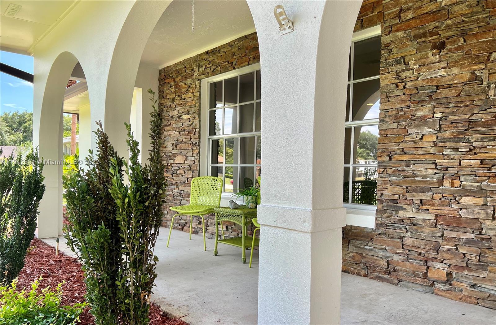 3052 Pine Cove Place Eustis, FL 32726 - Photo 4 of 32 a view of a door with a bench and potted plants