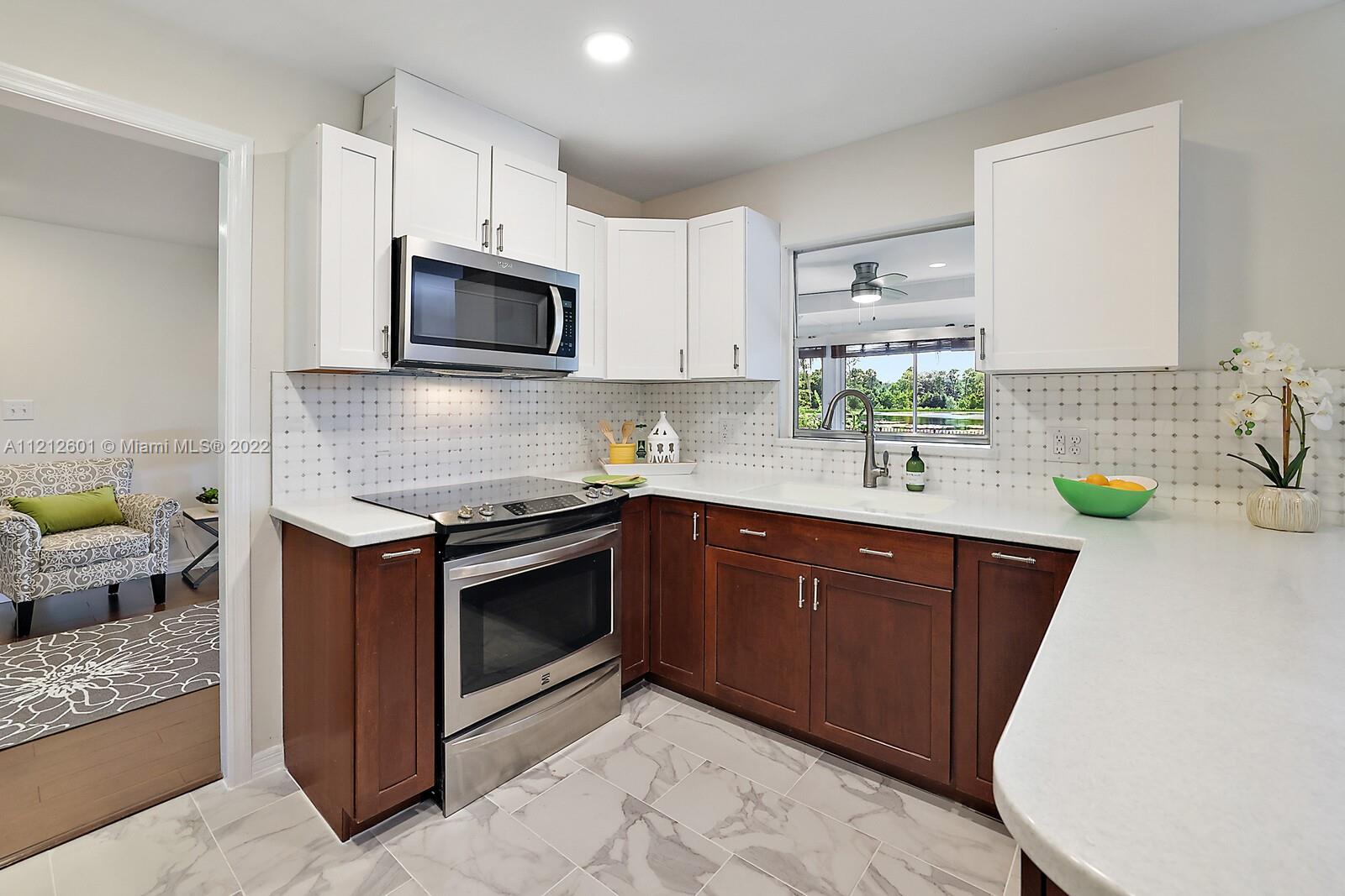3052 Pine Cove Place Eustis, FL 32726 - Photo 8 of 32 a kitchen with stainless steel appliances granite countertop a sink dishwasher stove and microwave