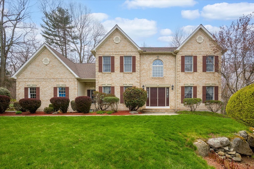 a front view of a house with a garden and yard