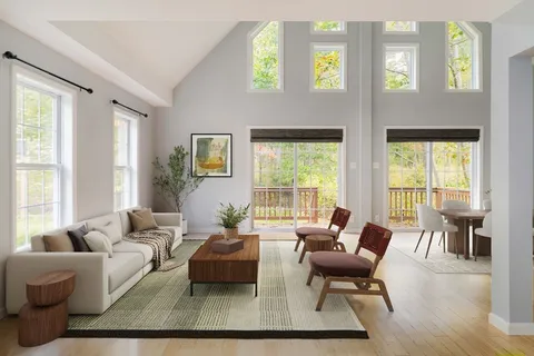 a living room with furniture wooden floor and a large window