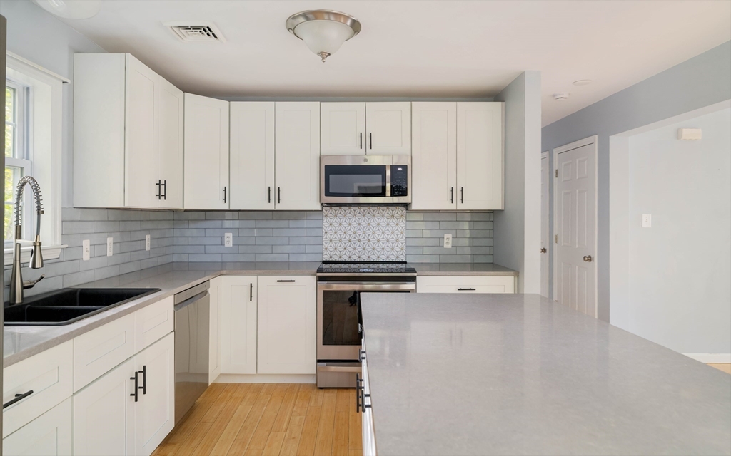 267 Carlisle Road Bedford, MA 01730 - Photo 17 of 32 a kitchen with granite countertop a stove and a sink