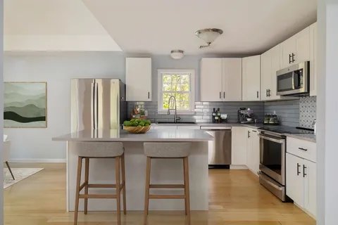 a kitchen with stainless steel appliances granite countertop a stove a sink refrigerator and microwave