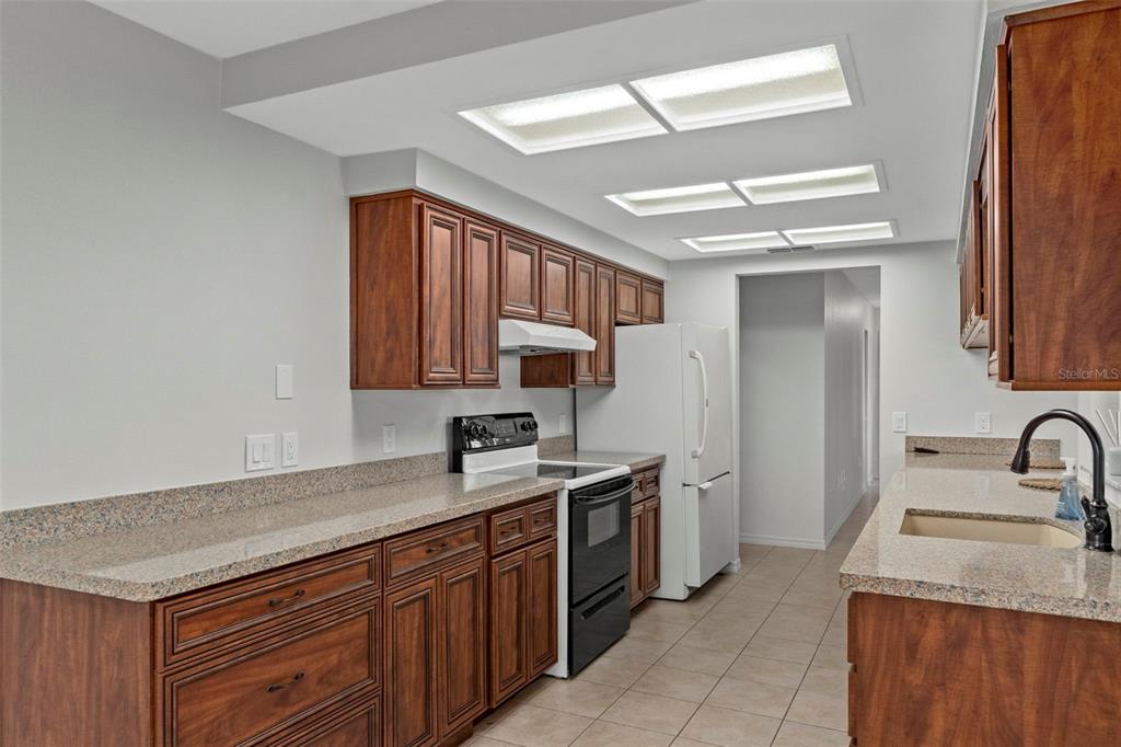 8332 Berkeley Manor Boulevard Spring Hill, FL 34606 - Photo 12 of 47 a kitchen with a sink stove and cabinets