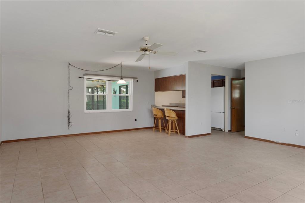 8332 Berkeley Manor Boulevard Spring Hill, FL 34606 - Photo 18 of 45 an empty room with chandelier fan and windows