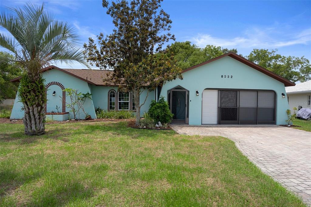8332 Berkeley Manor Boulevard Spring Hill, FL 34606 - Photo 2 of 45 a view of a house with a yard and large tree