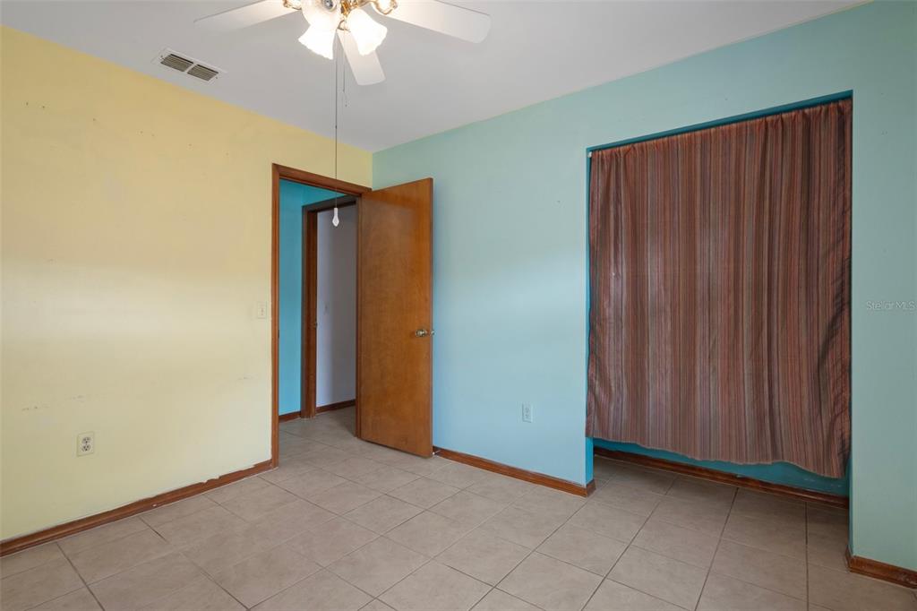 8332 Berkeley Manor Boulevard Spring Hill, FL 34606 - Photo 33 of 45 an empty room with a chandelier fan and closet