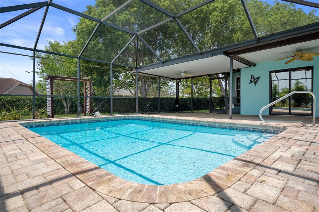 8332 Berkeley Manor Boulevard Spring Hill, FL 34606 - Photo 8 of 45 a view of a patio with a table and chairs under an umbrella