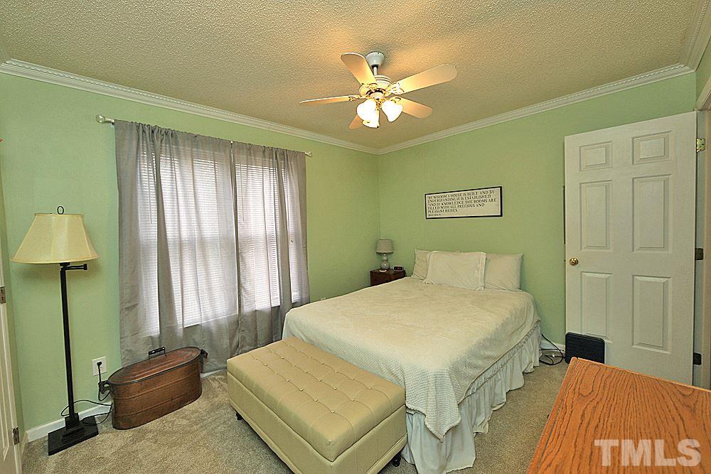 2804 Livery Way Raleigh, NC 27603 - Photo 12 of 24 a bedroom with a bed and a chandelier