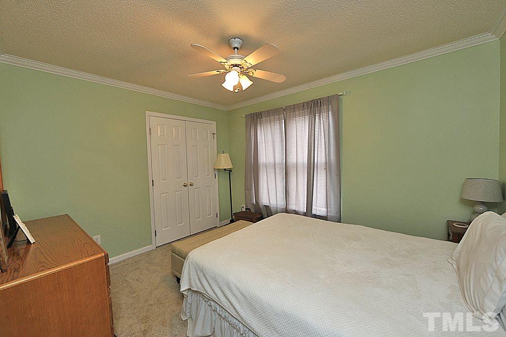 2804 Livery Way Raleigh, NC 27603 - Photo 13 of 24 a bedroom with a bed and a chandelier