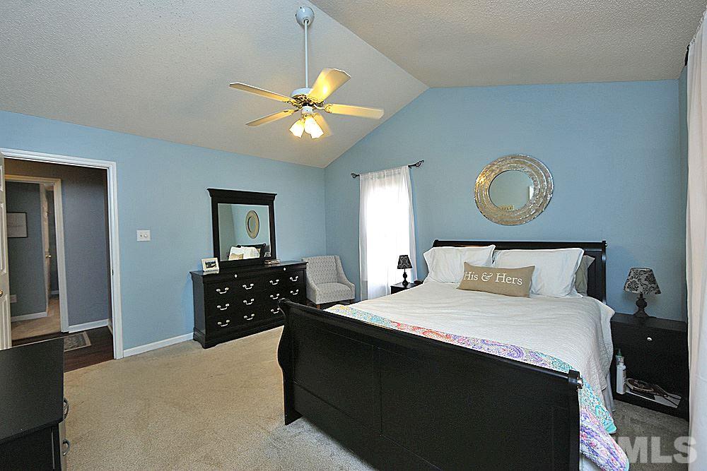 2804 Livery Way Raleigh, NC 27603 - Photo 16 of 24 a bedroom with a bed and a chandelier