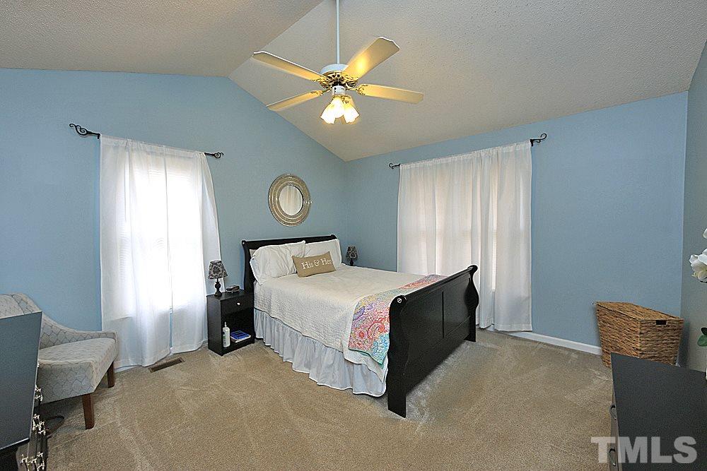 2804 Livery Way Raleigh, NC 27603 - Photo 17 of 24 a spacious bedroom with a bed and a chandelier