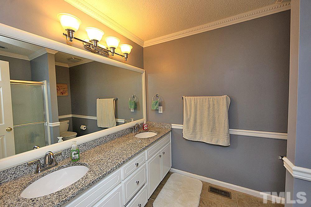 2804 Livery Way Raleigh, NC 27603 - Photo 19 of 24 a bathroom with a granite countertop sink and a mirror