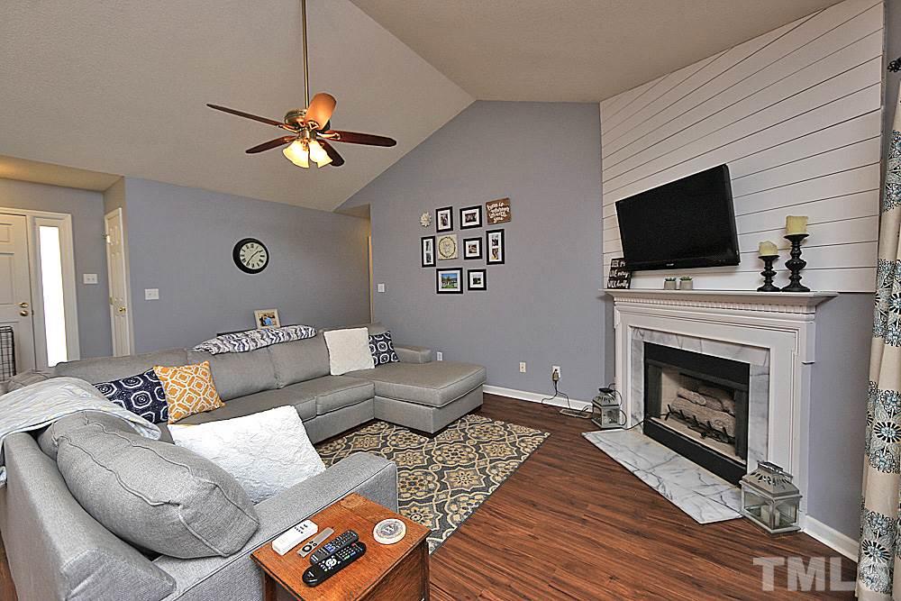 2804 Livery Way Raleigh, NC 27603 - Photo 5 of 24 a living room with furniture a flat screen tv and a fireplace