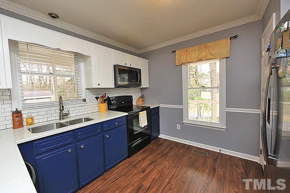 2804 Livery Way Raleigh, NC 27603 - Photo 10 of 24 a kitchen with wooden floors cabinets a sink and appliances