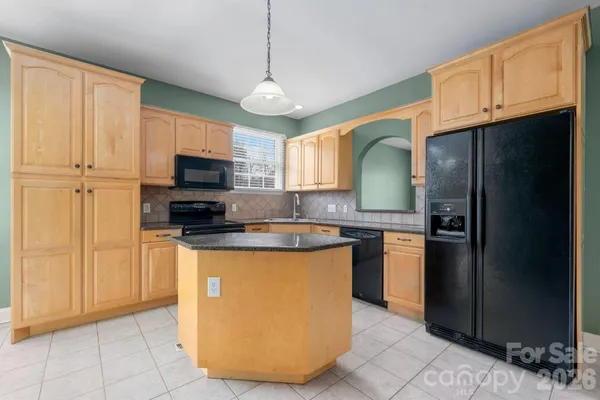 a kitchen with stainless steel appliances granite countertop a refrigerator a sink a stove a microwave and island