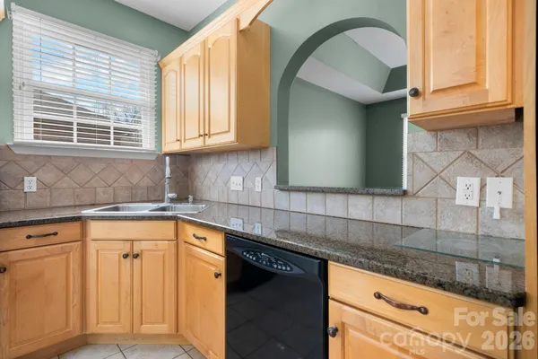 a kitchen with granite countertop a sink and cabinets