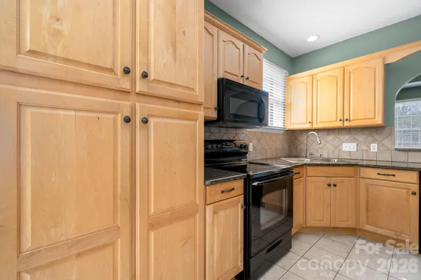a kitchen with granite countertop cabinets stainless steel appliances and a sink