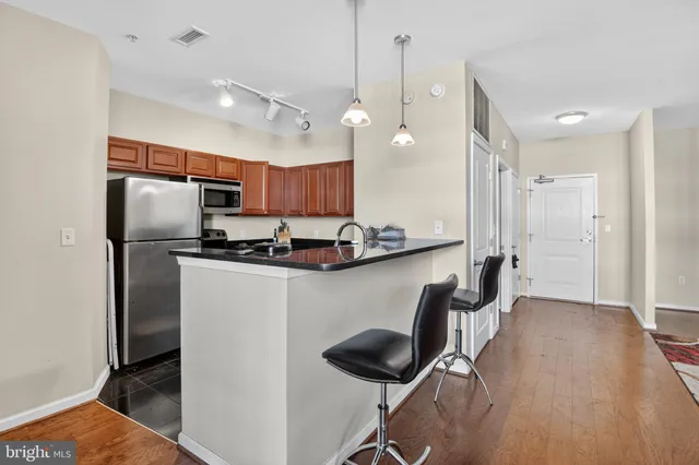 a kitchen with kitchen island a counter top space appliances and a ceiling fan
