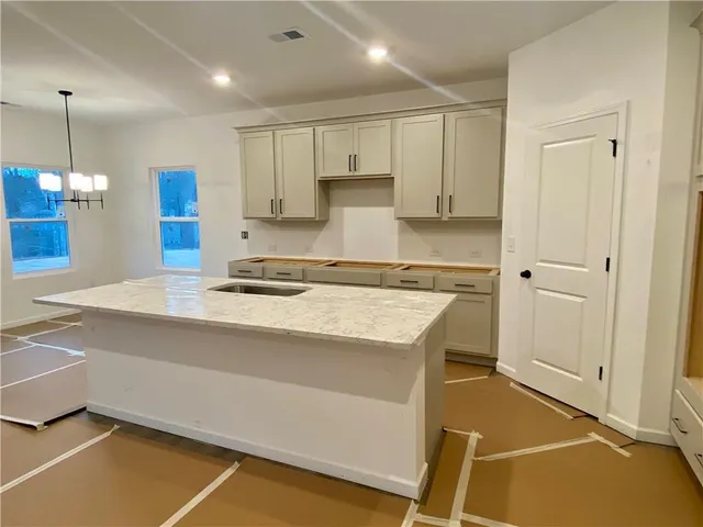 a kitchen with kitchen island a stove a sink and a refrigerator