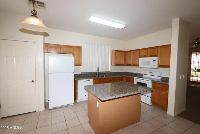 a kitchen with granite countertop a sink and a refrigerator