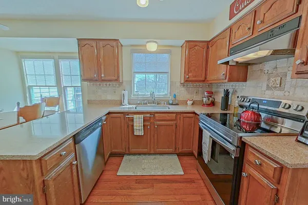 a kitchen with stainless steel appliances granite countertop a sink stove and cabinets