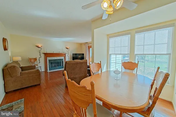 a living room with furniture a chandelier a large window and flat screen tv