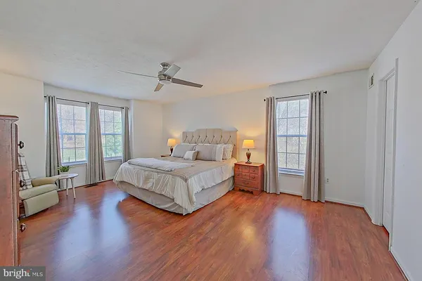 a spacious bedroom with a bed and wooden floor