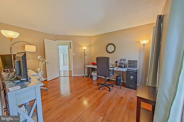 a view of a workspace with furniture and wooden floor