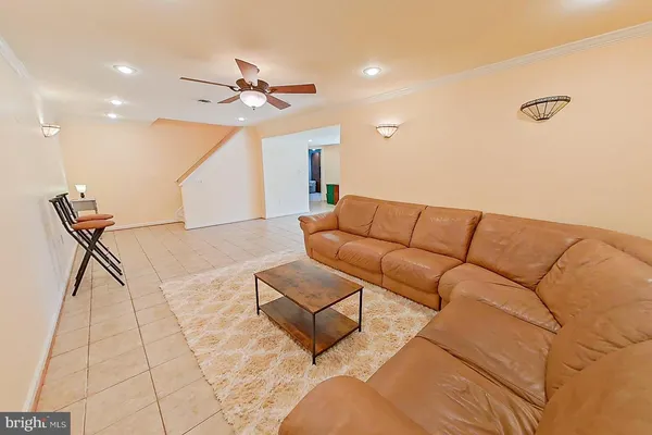 a living room with furniture and a ceiling fan