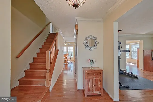 a view of a hallway with wooden floor and stairs