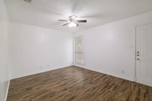 a view of a room with wooden floor and a ceiling fan