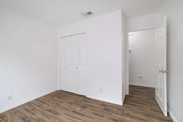 a view of an empty room with wooden floor
