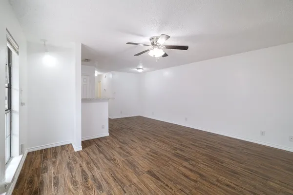 a view of empty room with wooden floor