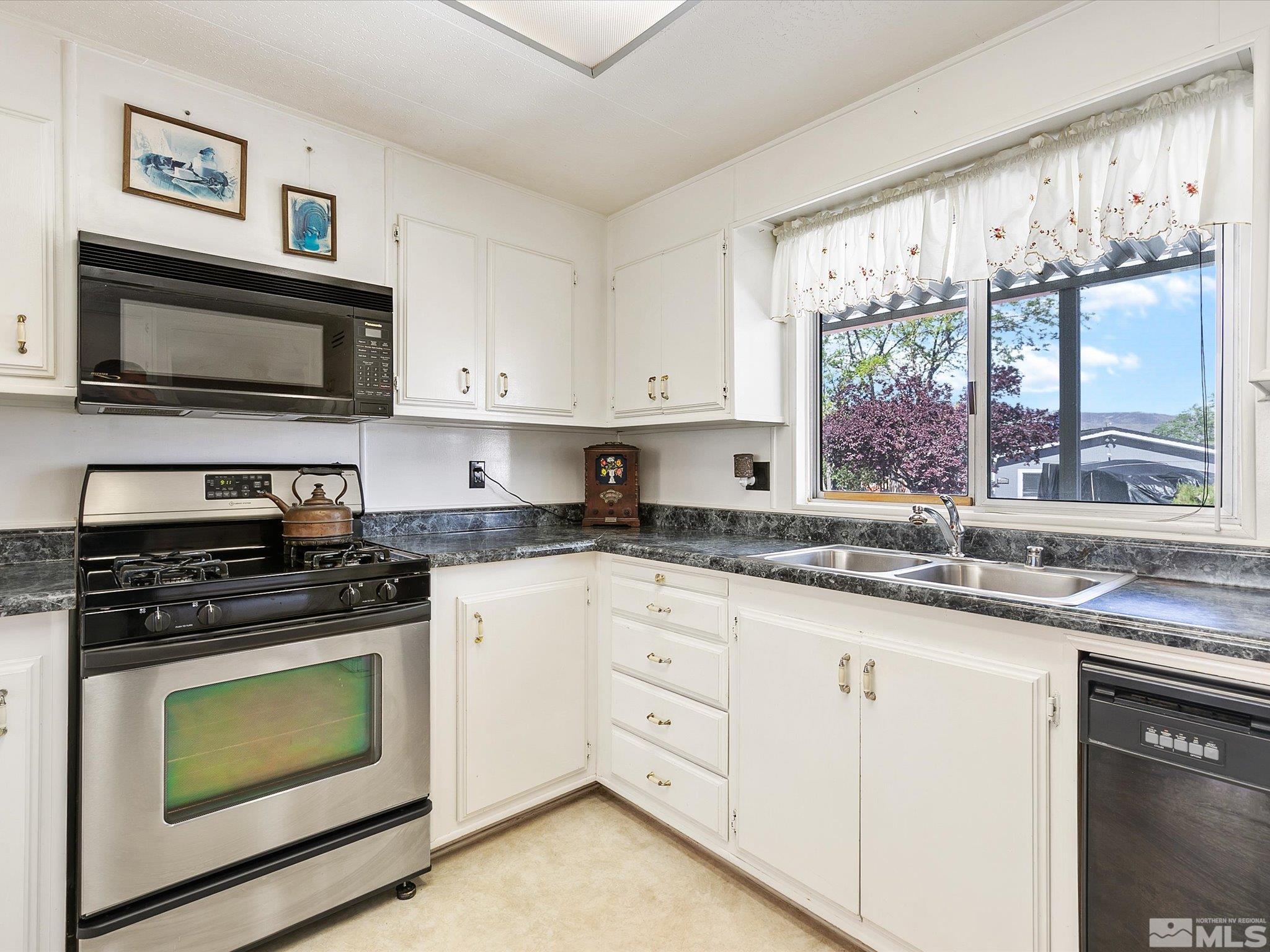 15010 Vega Street Reno, NV 89521 - Photo 11 of 30 a kitchen with granite countertop a stove a sink and a microwave