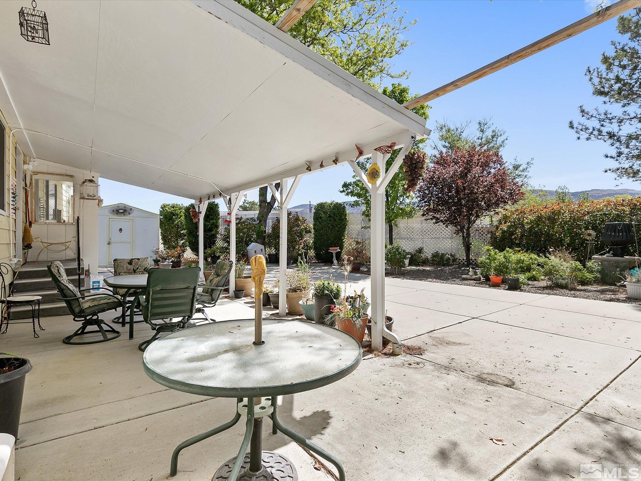 15010 Vega Street Reno, NV 89521 - Photo 25 of 30 a patio with a table and chairs and potted plants