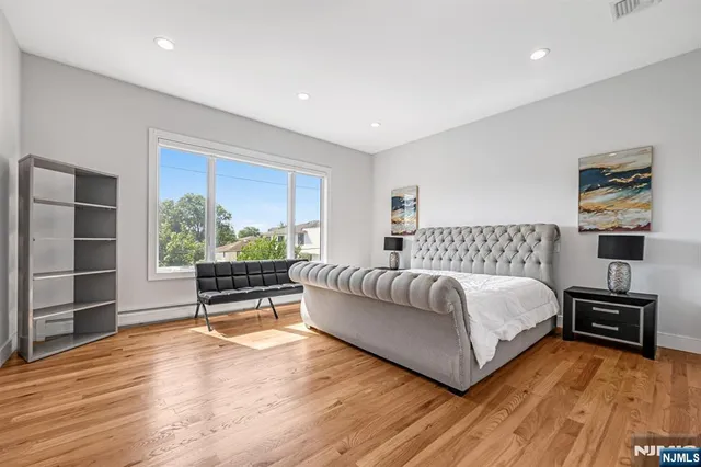 a bedroom with a bed and a painting on the wall