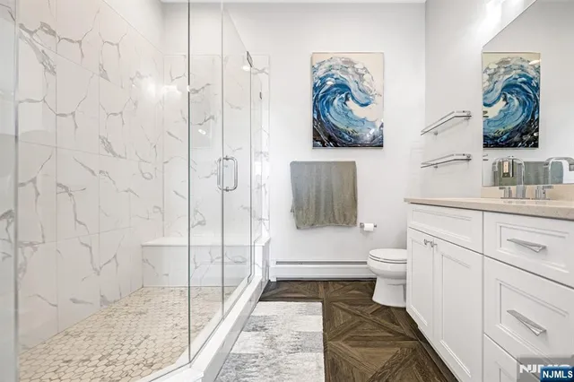 a bathroom with a granite countertop toilet sink and mirror