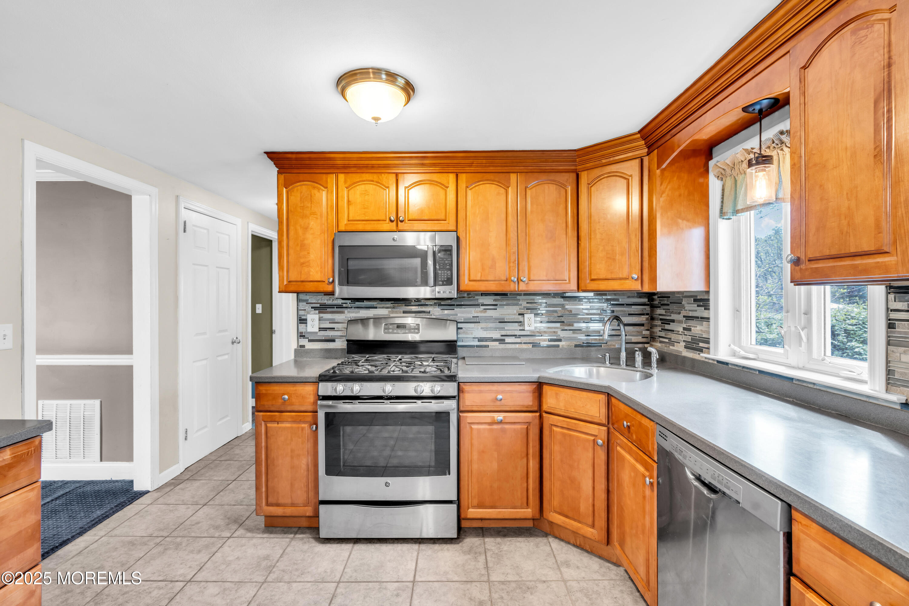 606 E Road Middletown, NJ 07748 - Photo 9 of 28 a kitchen with a stove a sink and a microwave