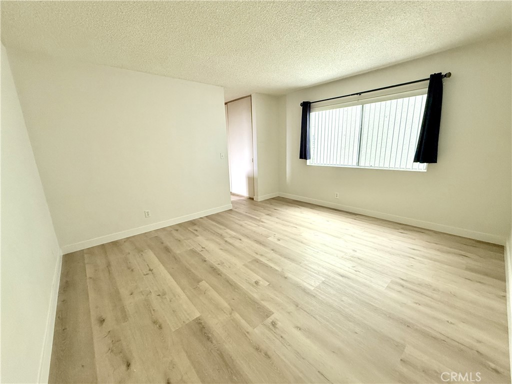1301 South Atlantic Boulevard, Unit 234C Monterey Park, CA 91754 - Photo 14 of 27 an empty room with wooden floor and windows