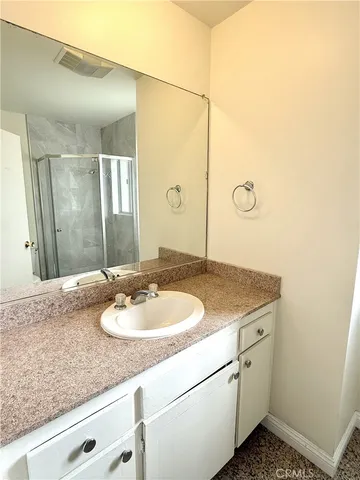 a bathroom with a granite countertop sink and a mirror