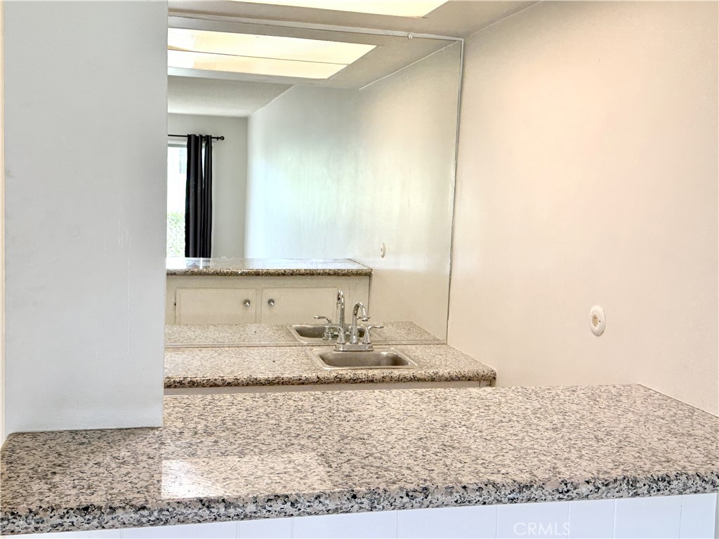 1301 South Atlantic Boulevard, Unit 234C Monterey Park, CA 91754 - Photo 16 of 27 a bathroom with a granite countertop sink and a mirror