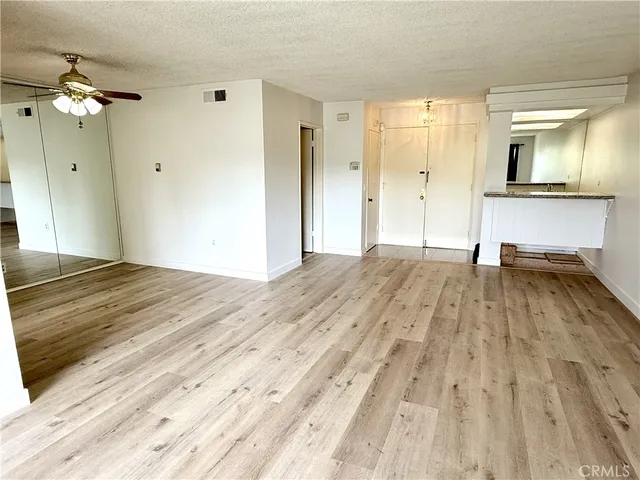 a view of empty room with wooden floor